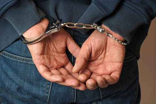 Elderly man in handcuffs
